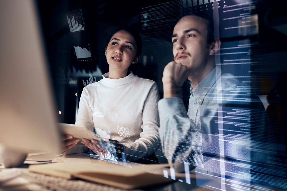 2 Mitarbeiter sitzen vor einem Computer und machen eine IT Notfallplan Schulung.